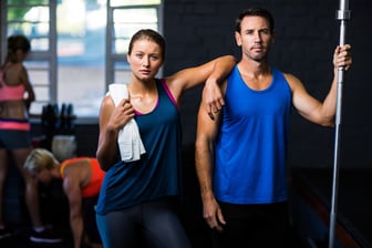 Portrait of fit serious friends standing in gym